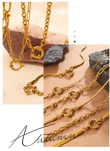 Detail view of gold-plated paperclip and snake chains with O-ring clasp on natural stone