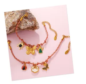 Detail of woven rope bracelets with butterfly, angel, and ladybug charms on stones