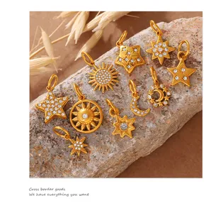 Detail of celestial gold charms with rhinestones on natural stone background