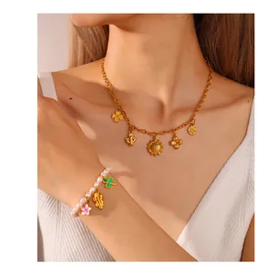 Detailaufnahme der Kleeblatt-Anhänger und Perlenarmband am Modell für Pflanzenschmuck-Set