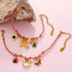 Braided rope bracelet set with butterfly and heart charms on rustic stone base