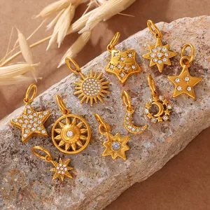 Golden star and moon charms with rhinestones displayed on a natural stone base