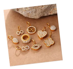 Detailed view of nine gold-plated charms with micro-pave crystals for DIY jewelry making