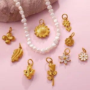 Unregelmäßige Perlenkette mit verschiedenen goldenen Blumenanhängern auf Rosa