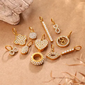 Elegant gold pendant charms with sparkling crystals in heart and clover shapes