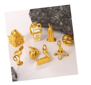 Macro shot of assorted gold-plated pendants featuring Eiffel Tower and cocktail glass charms