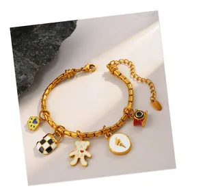 Detail of gold beaded bracelet with checkerboard bag and British bear charms