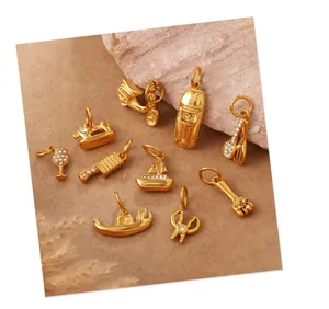 Dettaglio macro di mini ciondoli dorati a forma di macchina da cucire con piccoli cristalli