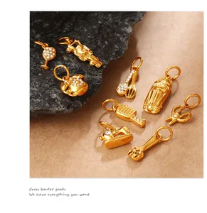 Dettaglio macro di ciondoli vintage dorati con strass e forme di piccoli utensili