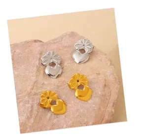 Close-up of gold and silver heart-shaped earring backs on a textured pink stone base