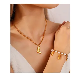 Detail of vintage gold cowboy boot pendant with pearl bracelet and elegant necklace