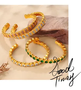 Detailed view of three gold-plated C-shaped cuffs with colorful cubic zirconia accents