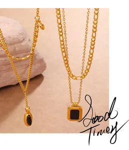 Detailed macro view of vintage 18K gold Figaro chain necklaces with black square pendants