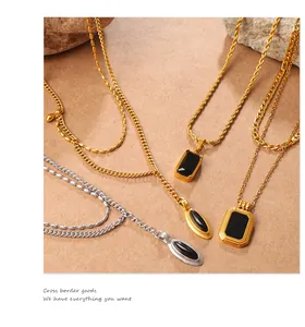 Detail of vintage gold and silver necklaces with black stone pendants on a textured background