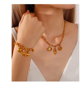 Dettaglio di ciondoli a stella marina e conchiglia in oro 18K su collana a maglie