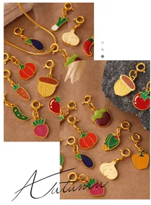 Macro detail of enamel fruit and vegetable pendants with golden spring clasps for DIY jewelry