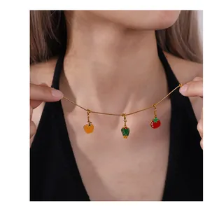 Detailed view of a gold chain necklace with colorful pepper and tomato vegetable charms