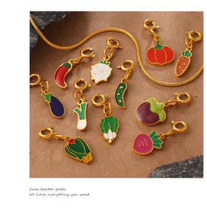 Detailed view of colorful vegetable charms including carrot and chili with gold lobster clasps