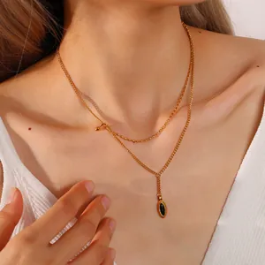 Vintage double layer gold necklace with black oval pendant on elegant female model