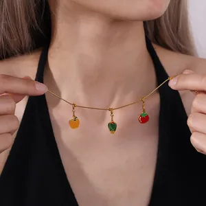 Golden necklace with colorful enamel vegetable charms of pepper, tomato and greens on model