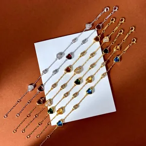Vue détaillée des bracelets en or et argent avec gemmes en cœur colorées et zircons ronds