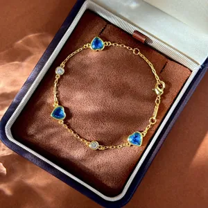 Détail du bracelet doré avec gemmes bleues en cœur et zircons ronds sur velours