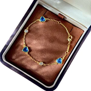 Bracelet élégant en chaîne dorée avec trois pierres bleues en cœur et diamants ronds
