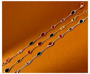 Close-up of three metal chains with colorful drop and marquise cut gemstone pendants