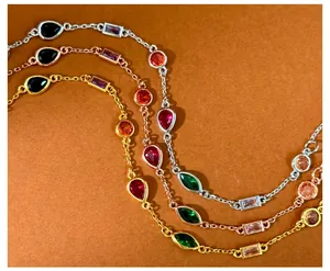 Detailed view of gold and silver chain bracelets with colorful multi-shape gemstones