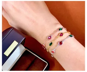 Three thin bracelets with colorful pear and marquise-cut gems in silver, gold, and rose gold