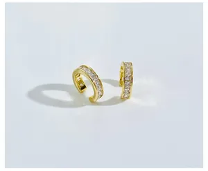Detail of gold-plated C-shaped ear cuffs with vertical-set square-cut cubic zirconia