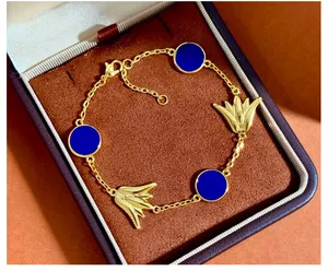 Detailansicht des goldenen Armbands mit blauen Scheiben und Tulpenmotiven in einer Box