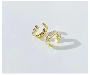 Detail of gold-plated C-shaped ear cuffs featuring a row of square-cut sparkling crystals