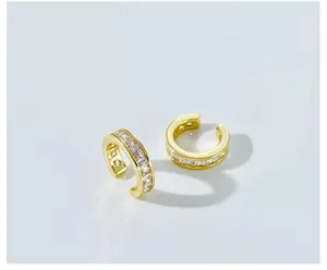 Close-up of gold-plated C-shaped ear cuffs set with rectangular clear cubic zirconia