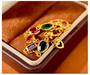 Detail of colorful faceted stones and heart charm on a golden chain in a velvet box