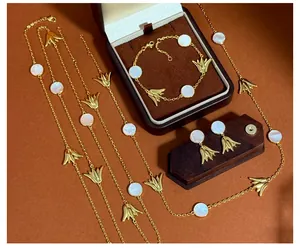 Detaillierte Nahaufnahme goldener Blumenanhänger mit weißen Muschel-Inlays auf Schmuck