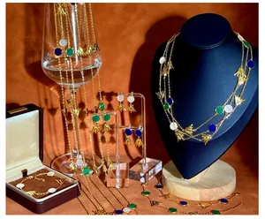 Detail eines Goldblumen Schmucksets mit weißer Muschel und blauen Quastenelementen