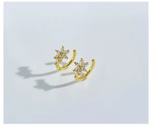 Macro shot of gold-plated flower earrings with marquise-cut sparkling zircons