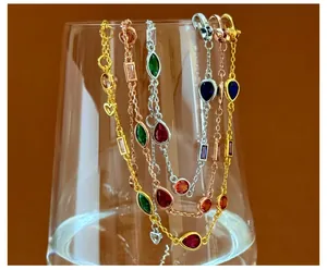 Detailed view of colorful multi-shape gemstones on gold and silver plated link chains