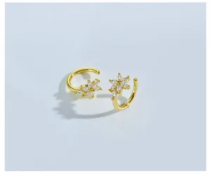 Macro view of gold flower earrings with sparkling crystals and a polished circular base