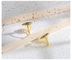 Macro shot of asymmetric gold-plated metal earrings with opal-like yellow resin inlays
