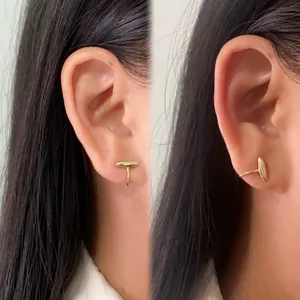 Minimalist asymmetric opal ear clips in gold geometric design worn by a female model