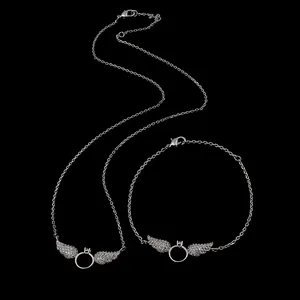 Close-up of sparkling angel wing necklace and bracelet set with silver cubic zirconia