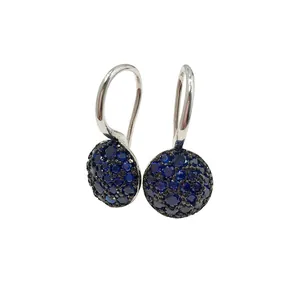 Macro shot of silver drop earrings with pavé set dark blue and black gemstones