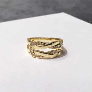 Macro view of gold plated crisscross U-ring featuring pave set sparkling zircon stones