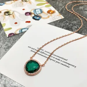 Détail du collier en or rose avec pierre verte facettée et contour en diamants pavés
