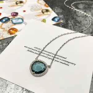 Détail macro du collier avec cristal bleu triangulaire et bordure en zircone blanc