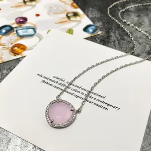 Détail du collier argenté avec pendentif en pierre rose et halo de zircons