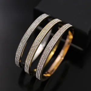 Détails de trois rangées de cristaux de zircon sur des bracelets en métal tricolore