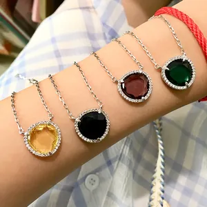 Détail de colliers en cristal coloré avec halo de diamants micro-pave sur le bras